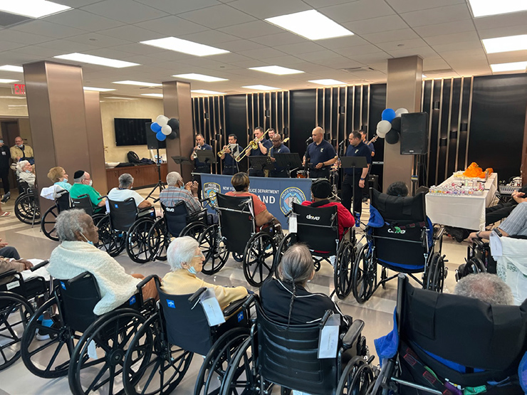 A group of people in wheelchairs watching a band playing musical instruments